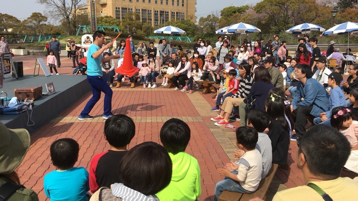 愛知県碧南市の明石公園にて観客の前でカラーコーンのジャグリングを披露する大道芸人丸ちぇろ