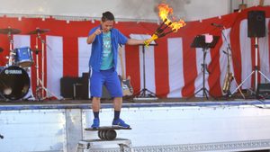 ローラーバランスの上でファイヤーのジャグリングに挑戦する大道芸人丸ちぇろ。滋賀県東近江市の永源寺運動公園グラウンドにて開催された「みんなの夏祭り(まちづくり協議会主催)」に出演させていただきました。