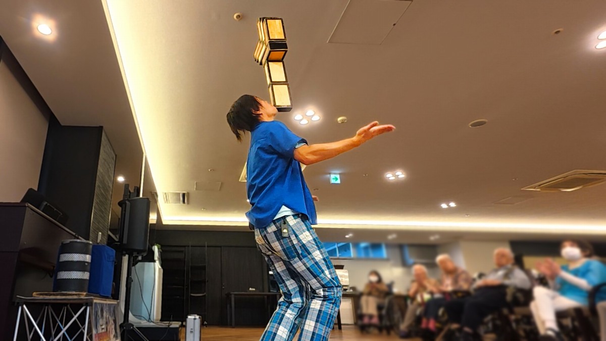 京都府宇治市の「スーパー・コート プレミアム宇治」にて9個の箱のバランス芸(チンバランス)を披露する大道芸人丸ちぇろ